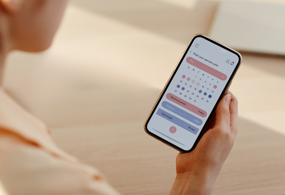 closeup of smartphone with a calendar app open that says, "mark your period cycle" at the top